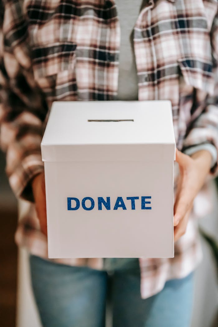 about-01 Close-up of a person holding a 'donate' box, encouraging charity and support.